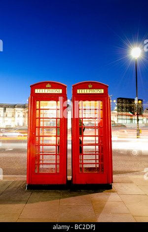 Rote Telefonzellen in der Nacht neben dem Trafalgar Square, London Stockfoto