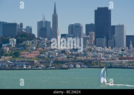 Ein Segelboot verläuft entlang der Uferpromenade von San Francisco mit der Transamerica Gebäude im Hintergrund. Stockfoto