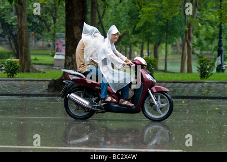 Zwei Personen auf einem Motorrad im Regen in Hanoi Vietnam Stockfoto