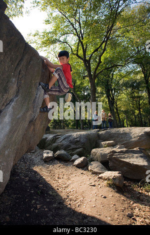 Ein junger Kletterer Bouldern im Central Park. Stockfoto