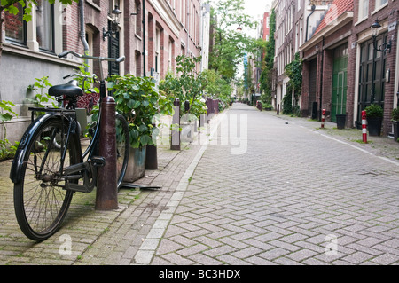 Fahrrad auf eine leere Straße in Amsterdam, mit vielen Pflanzen geparkt. Stockfoto