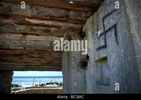 Historische WW2 deutsche Waffe und Lookout Betonbunker mit Hakenkreuz Graffiti mit Blick auf die Strände von Fort-Mahon-Plage-Frankreich Stockfoto