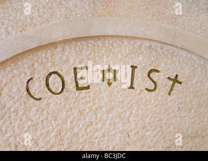 Das Wort "nebeneinander" schriftliche auf einen öffentlichen Brunnen mit dem Symbol der drei monotheistischen Religionen: Kreuz, Mond, Davidstern. Stockfoto