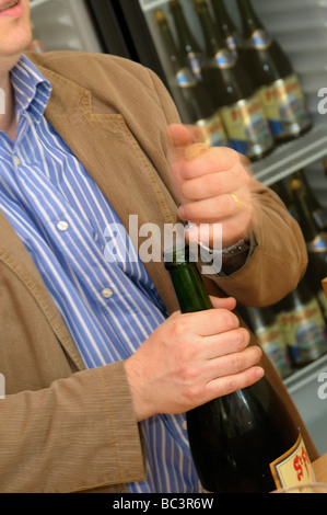 St Feuillien Direktor der Produktion Alexis Briol knallt den Korken auf eine Flasche Bier in der Brauerei-Probierstube. Stockfoto