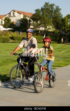 Kinder Vater Kind 8-9 Jahre alten Fahrrad Fahrrad Fahrräder Fahrrad zusammen außerhalb von Kalifornien ethnischen Elternteil ethnischen United States © Myrleen Pearson Stockfoto