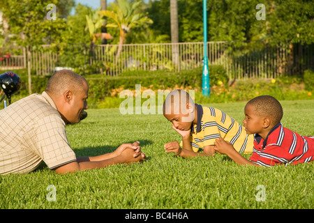 Gespräch. Afrikaner - Eltern Vater und Söhne im Gespräch das Gespräch miteinander draußen auf der wiese Seite Profil ansehen HERR © Myrleen Pearson Stockfoto