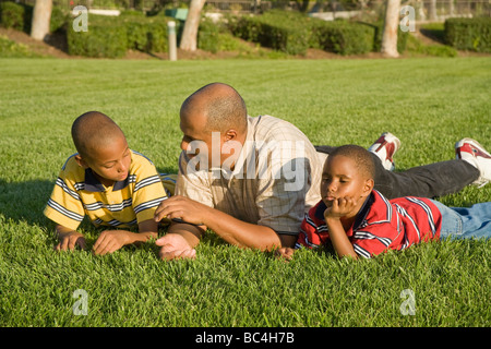 Gespräch. Afrikaner - Eltern Vater und Söhne im Gespräch das Gespräch mit jedem anderen externen Verlegung auf dem Gras Profil HERR © Myrleen Pearson Stockfoto