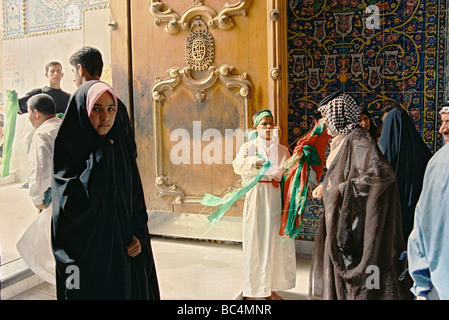 Gläubige an einem der Tore zum Imam Husain Moschee und Heiligtum in der heiligen Zeit der Ashura, in Kerbala, Irak. Stockfoto