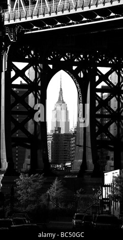 Empire State Building gesehen durch die Stützen der Manhattan Bridge Stockfoto