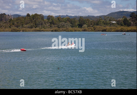 Kinder im Schlauchboot gezogen von Motorboot - Whananaki-Mündung, Northland, Nordinsel, Neuseeland Stockfoto