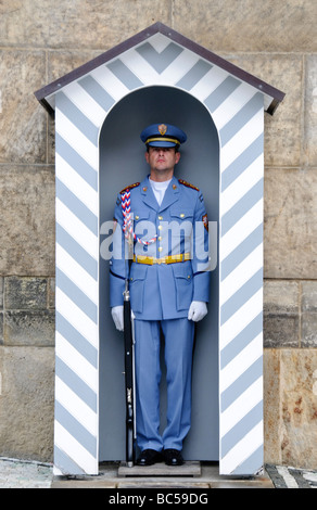 Prager Schlosswache in Sommeruniform auf der Prager Burg Tschechische Republik // PRAG, Tschechische Republik — Ein Mitglied der Prager Schlosswache (Hradní Stráž) steht in der hellblauen Sommeruniform am Eingang der Prager Burg im Wachdienst. Die Schlosswache ist eine Spezialeinheit der Streitkräfte der Tschechischen Republik, die für den Schutz und die Sicherheit des Schlosskomplexes verantwortlich ist. Diese Uniform wird vom 1. Mai bis zum 31. Oktober getragen, während der Wintermonate wird eine dunklere blaue Version verwendet. Der zeremonielle Wachwechsel ist ein beliebtes tägliches Ereignis für Besucher, mit der Hauptzeremonie Stockfoto