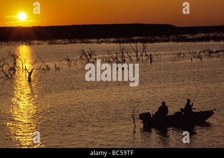 Angler am Boot Angeln bei Sonnenuntergang am Choke Canyon Stausee in Choke Canyon State Park Texas USA Stockfoto