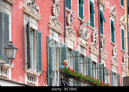 Eine Frau Wasser Gerranium Flowerboxes auf einem Balkon in Carrara Stockfoto