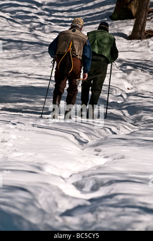 Zwei im Ruhestand Kollegen in Richtung zu einem Fluss einige späten Winter, Vorfrühling Lachsfischen in New Hampshire. Stockfoto