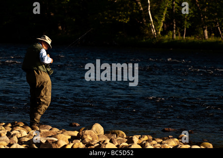 66 jährige pensionierte Mann Angeln im nördlichen NH am Androscoggin River. Stockfoto