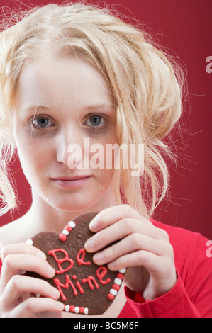 Traurige junge Frau mit Schokolade zum Valentinstag Herz- Stockfoto