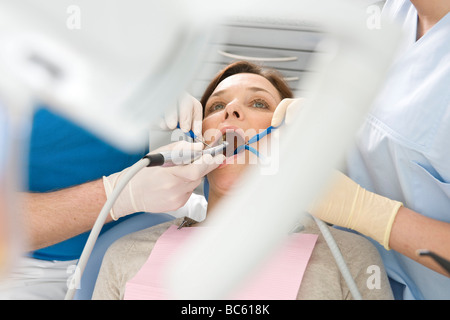 Männliche Zahnarzt und Assistenten, die Zähne des Patienten zu prüfen Stockfoto