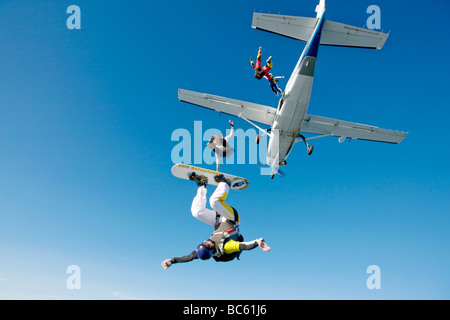 Vier Fallschirmspringer springen aus Propellerflugzeug, Schweiz Stockfoto