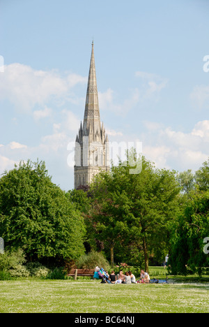 Picknicker im Queen Elizabeth Gardens mit Kathedrale von Salisbury in der Ferne Salisbury Wiltshire England Stockfoto