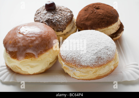 Vier verschiedene Donuts auf Pappteller- Stockfoto