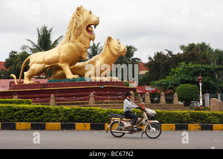 Kambodschanische Mann reitet moped um "Goldenen Löwen" Kreisverkehr, Sihanoukville, Kambodscha Stockfoto