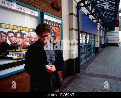 Mann stehend außen Kino warten Datum Blick auf Uhr aufgestanden Stockfoto