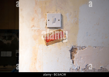 Eine Lightswitch auf einer verfallenen Mauer mit einem Schild unter "Gefahr" zu lesen. Stockfoto