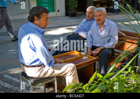 Türkei, Istanbul, Straßenszene der älteren Männer, die das Spiel sehr alte Backgammon oder Tavia auf Bürgersteig in der Abenddämmerung Stockfoto