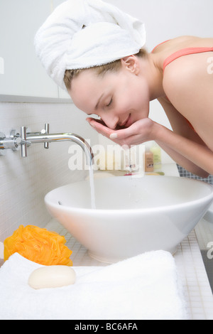 Junge Frau waschen Gesicht, Seitenansicht Stockfoto