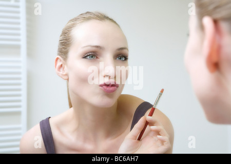 Junge Frau mit Pinsel, Lippen kräuseln Stockfoto