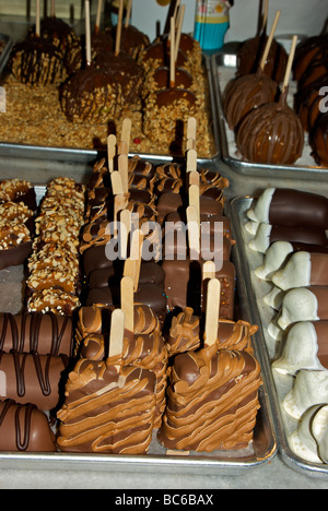 Alu-Schalen Schoko Nuss beschichtet fudge Süßigkeiten Konfekt auf Holzstäbchen Süßwarenladen Stockfoto