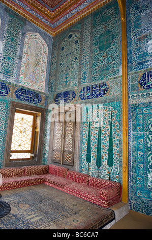 Türkei, Istanbul, Topkapi-Palast Sofas durch Fenster & blaue Fliesen Muster Wände & Kalligraphie Tafeln mit Zitaten aus dem Koran Stockfoto