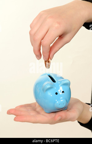 Kind, Geld in einem Sparschwein blau china Stockfoto
