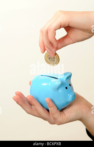 Kind, Geld in einem Sparschwein blau china Stockfoto