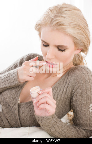 junge Frau Anwendung Lippenbalsam Stockfoto