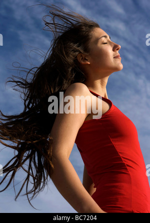 Attraktive junge Frau mit der Sonne im Gesicht Stockfoto