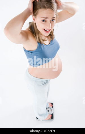 Schwangere Frau im Maßstab Stockfoto