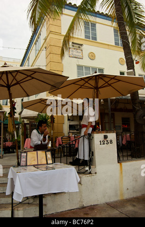 Maitre d und Kellner unter Sonnenschirmen im freien Restaurant Südstrand Miami Stockfoto