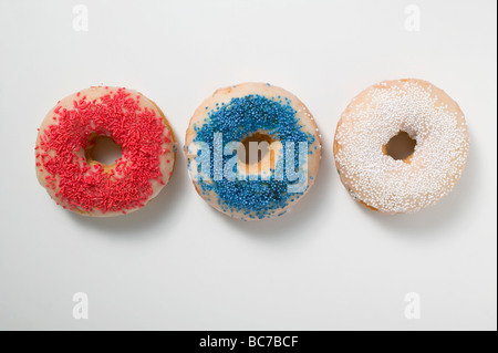 Drei Krapfen mit Streuseln (rot, blau, weiß)- Stockfoto