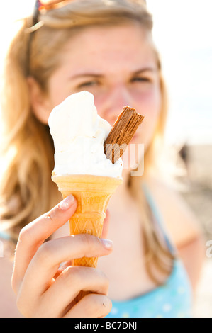 Ein junges Mädchen hält einen Softeis-Kegel mit einer Schokolade Flocken drin 99 Wales UK Stockfoto