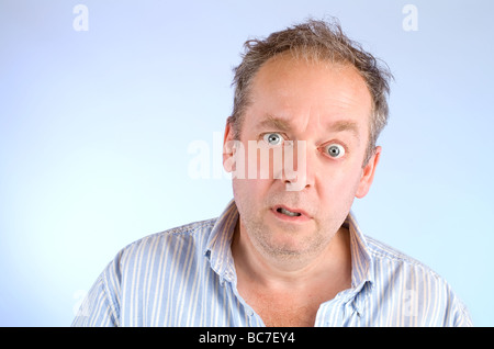 Ernst und ungepflegt aussehender Mann posiert und schaut in die Kamera Stockfoto