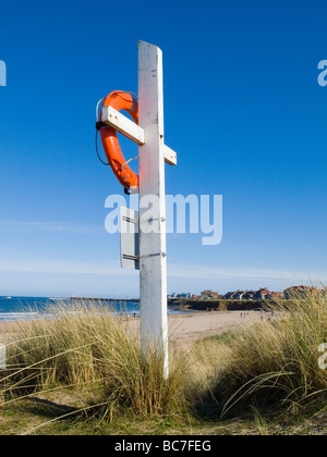 Nahaufnahme von einem hellen orange Rettungsring in den Dünen am Strand von gemeinsame, auf die schöne Northumberland Küste England UK Stockfoto