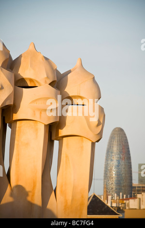 Schornsteine auf dem Dach der Casa Milà von Gaudi Stadt Skyline einschließlich der Agbar Turm im Hintergrund Barcelona Spanien Stockfoto