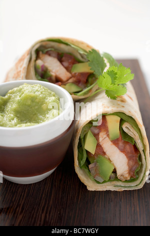 Zwei Hühnchen und Avocado wraps, Guacamole in kleinen Schüssel- Stockfoto