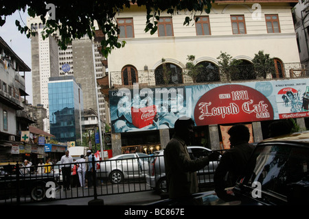 Eine Straßenansicht von Leopold Cafe und das Taj Hotel Hintergrund in Colaba in Mumbai, Indien Stockfoto