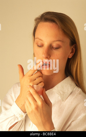 Frau ihre Lippen Lippenbalsam aufsetzen Stockfoto