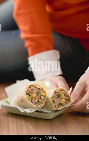 Frau sitzt mit Burritos - Erdgeschoss Stockfoto