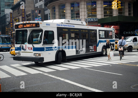 Ein elektrischer angetriebener MTA Hybridbus dreht sich im Verkehr auf dem Times Square in New York Stockfoto