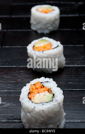 flachen Fokus vertikale Makro 3 Rollen von Sushi auf schwarzem Holz