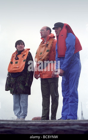 3 Matrosen an Land tragen Schwimmwesten. nass, regnet niedergeschlagen Stockfoto